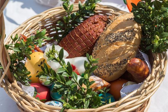 Košík s jídlem a vajíčky ozdobený zelenými větvičkami připravený na velikonoční požehnání